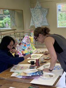 Carers being shown painting techniques by artist at class