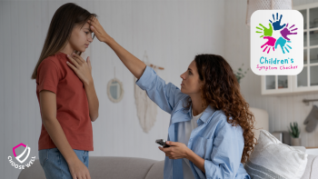 Mother kneeling down while checking her mobile phone and examinig her sich child by placing their hand on their forhead as if to check their temperature