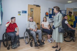 The Princess Royal meets service users at RABIU, three people in wheelchairs getting ready to play Boccia.