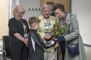 The Princess Royal is gifted a posy of flowers by a young boy.